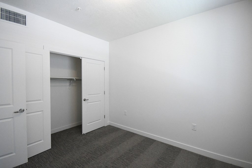 an empty room with white walls and a closet