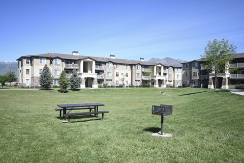 a park with a picnic table in front of an apartment building