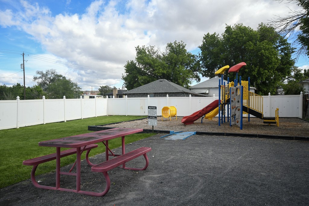 a playground in a park with a picnic table