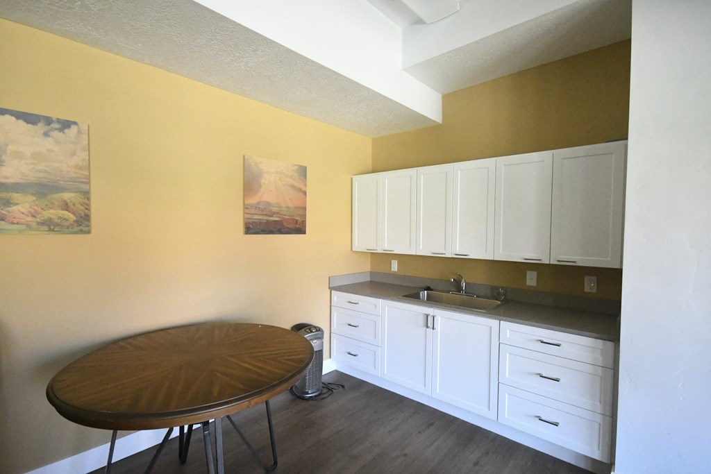 a kitchen with white cabinets and a wooden table