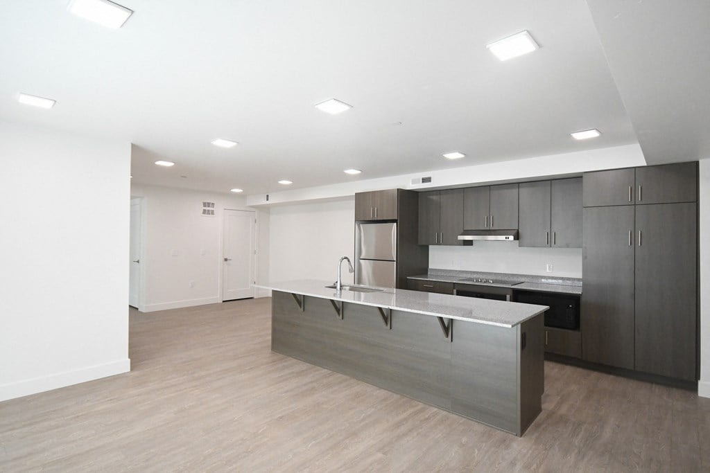 an empty room with an island in the middle of a kitchen