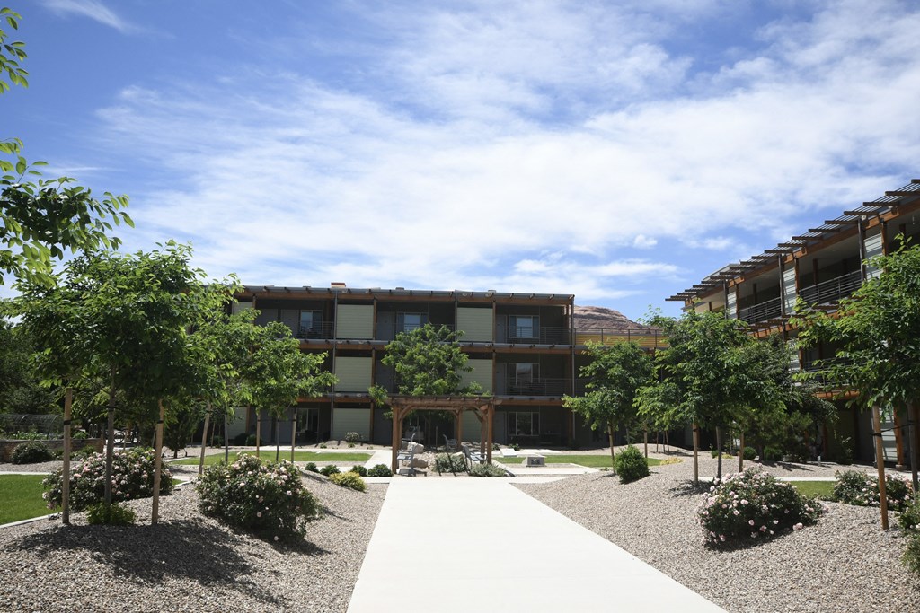 a courtyard with trees in front of an apartment building