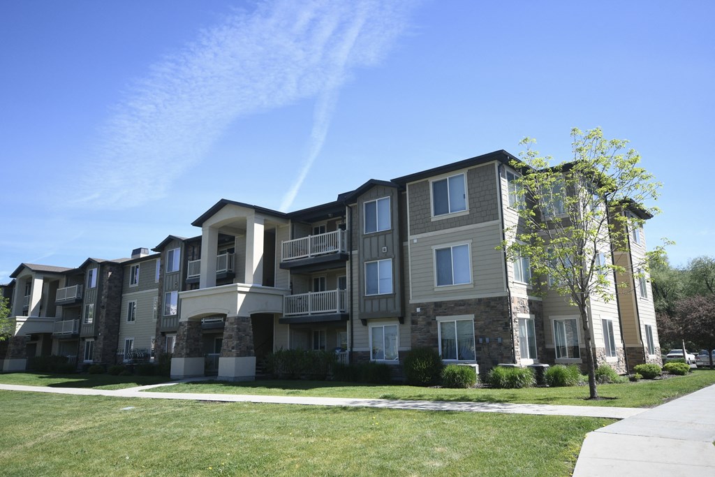 an apartment building with a sidewalk in front of it