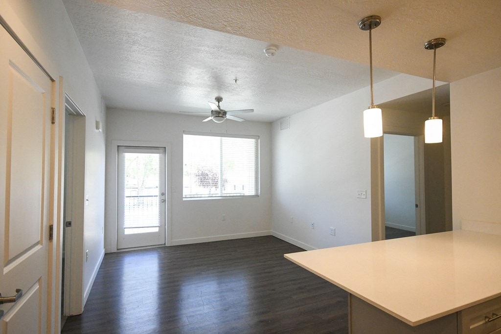 an empty kitchen and living room with a ceiling fan