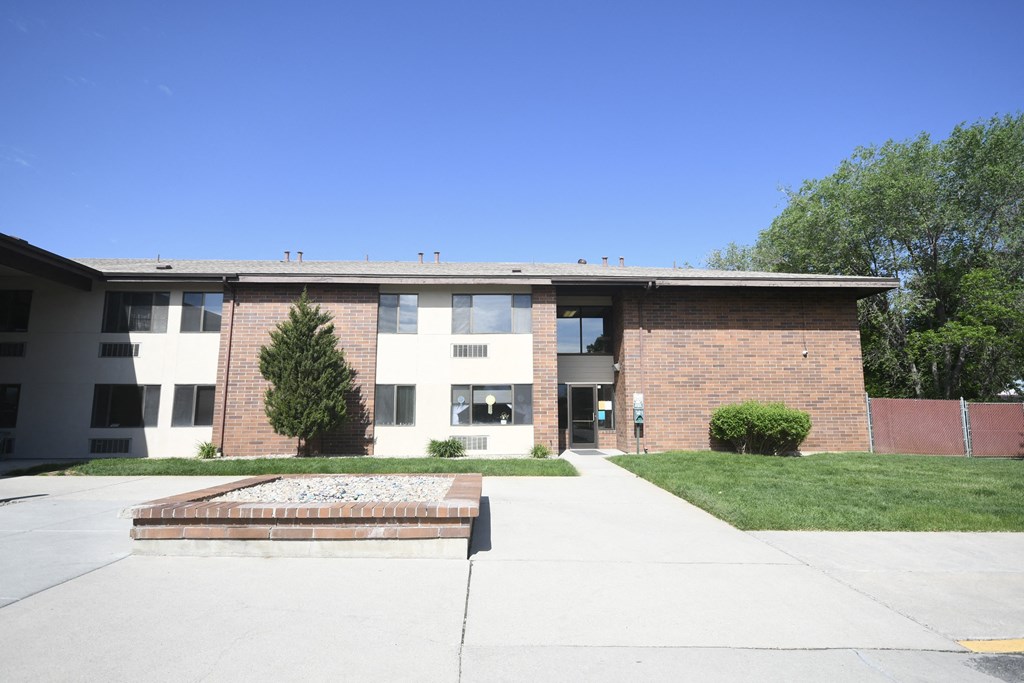 an apartment building with a sidewalk and grass