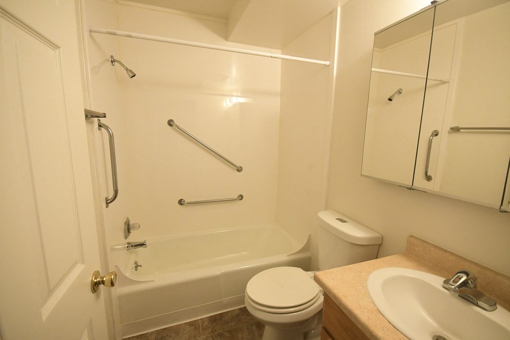 a bathroom with a shower and a sink and a toilet