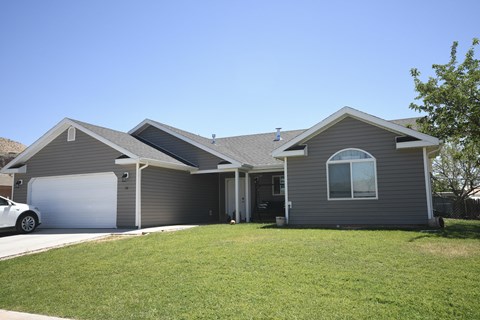 a gray house with a lawn and a garage