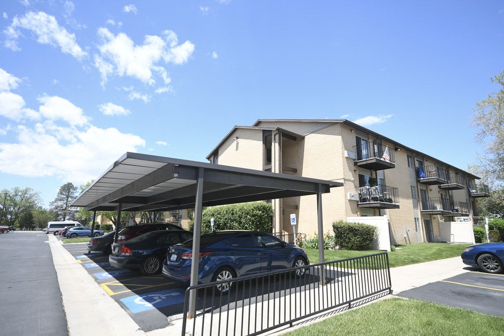 a parking lot with cars in front of an apartment building