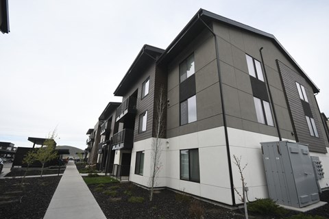 a row of apartment buildings with a sidewalk in front of them