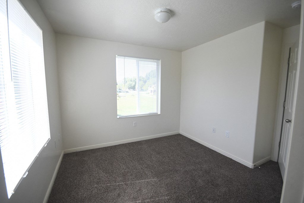 an empty room with carpet and a window