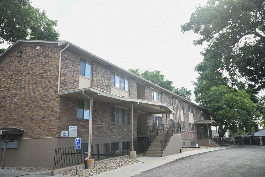 a brick building with stairs and a street in front of it