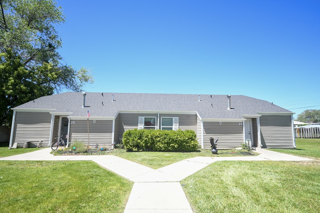 a gray house with a yard in front of it