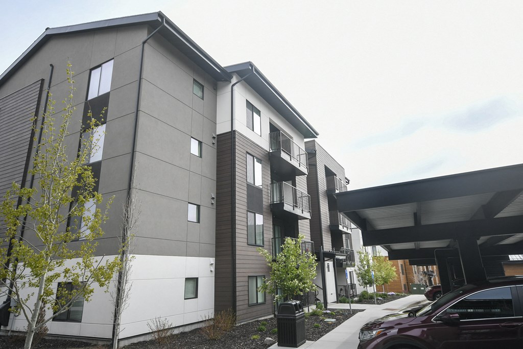 the exterior of a building with cars parked in front of it