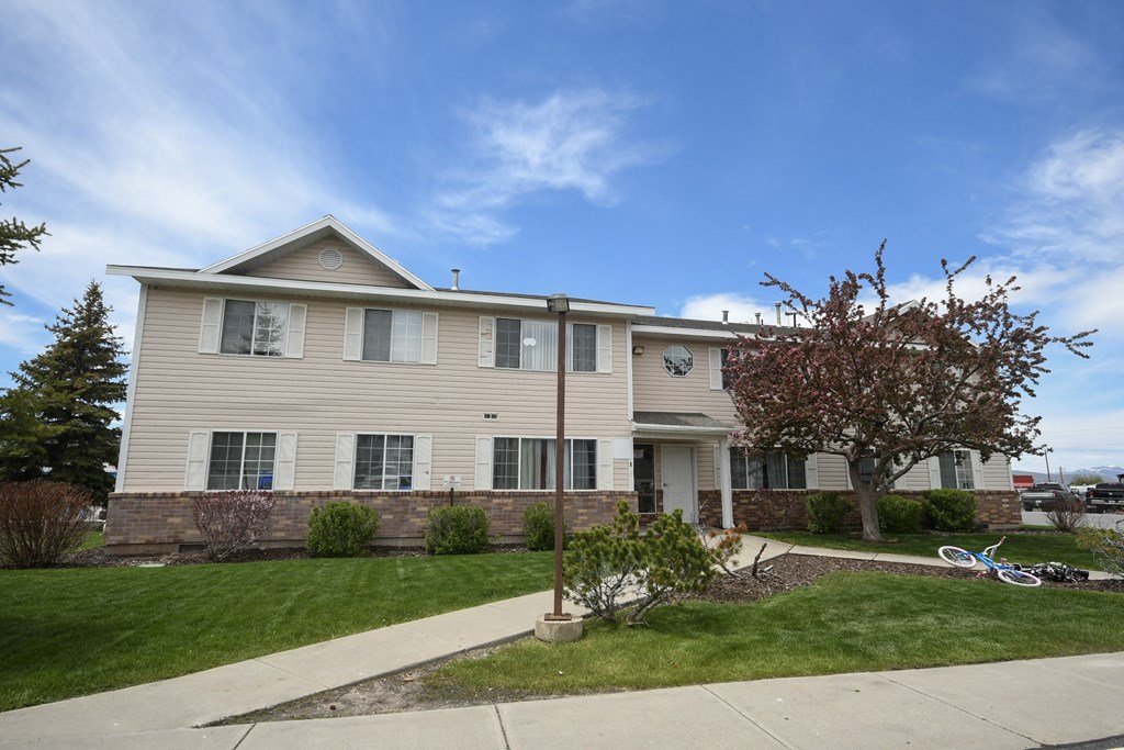 a tan house with a sidewalk in front of it