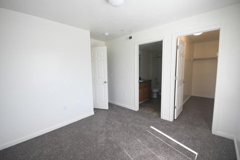 an empty bedroom with a closet and a bathroom