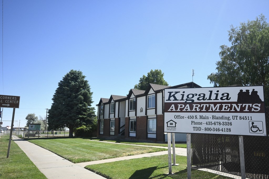 a sign in front of a building with apartments in the background
