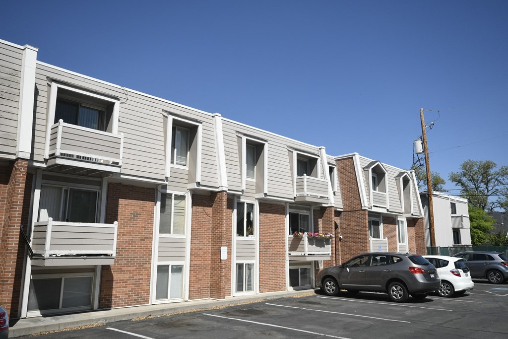an apartment building with cars parked in front of it