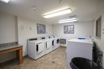 a washer and dryer room with a row of washing machines