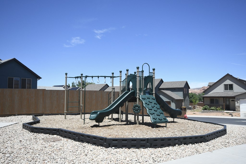 a playground in a neighborhood with a green slide