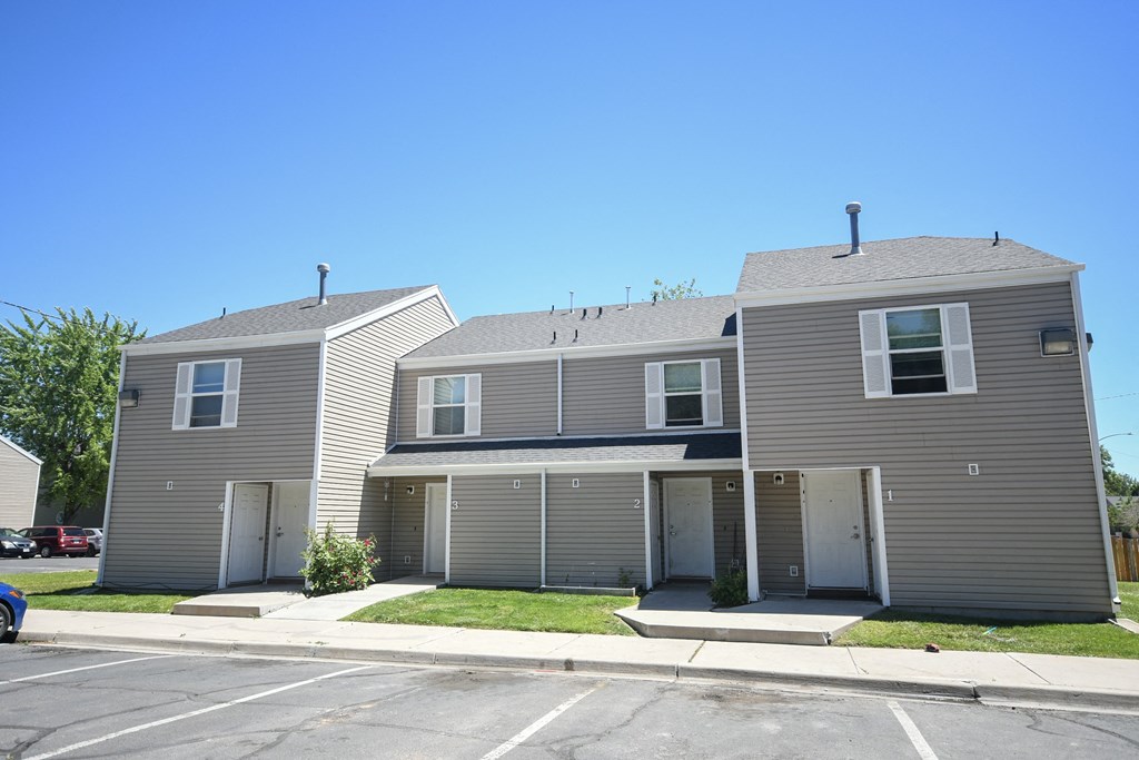 the front of a house with three garages and a lawn