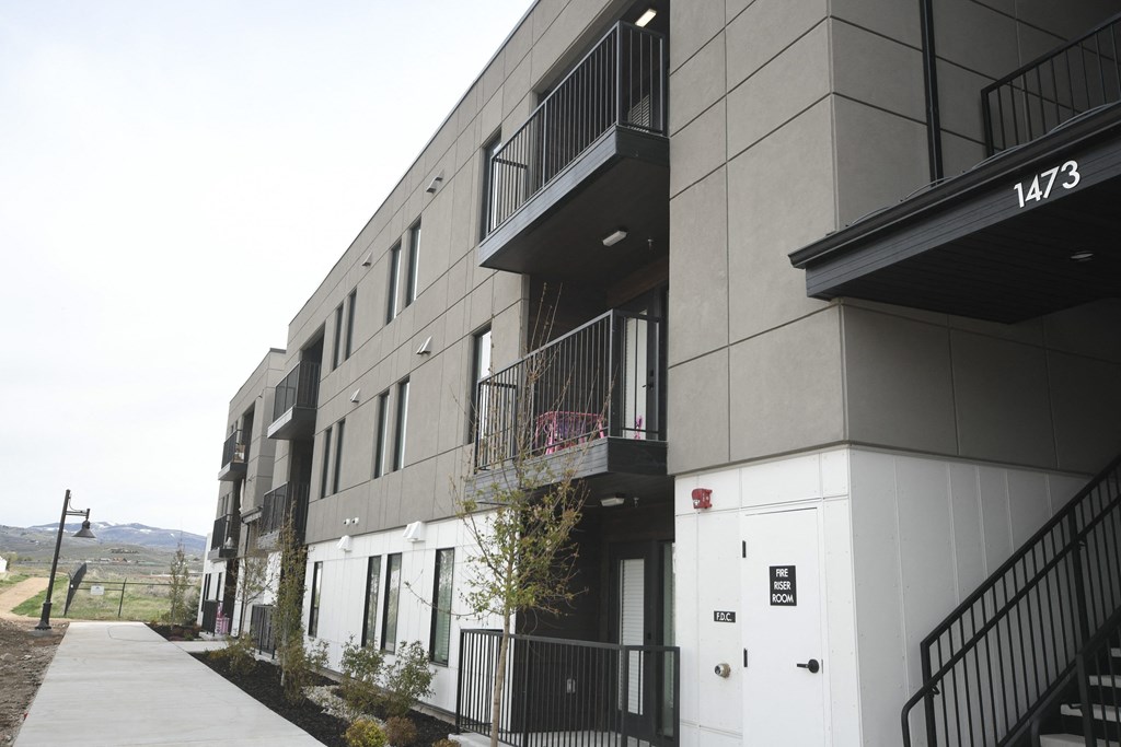 a row of apartment buildings with a sidewalk in front of them