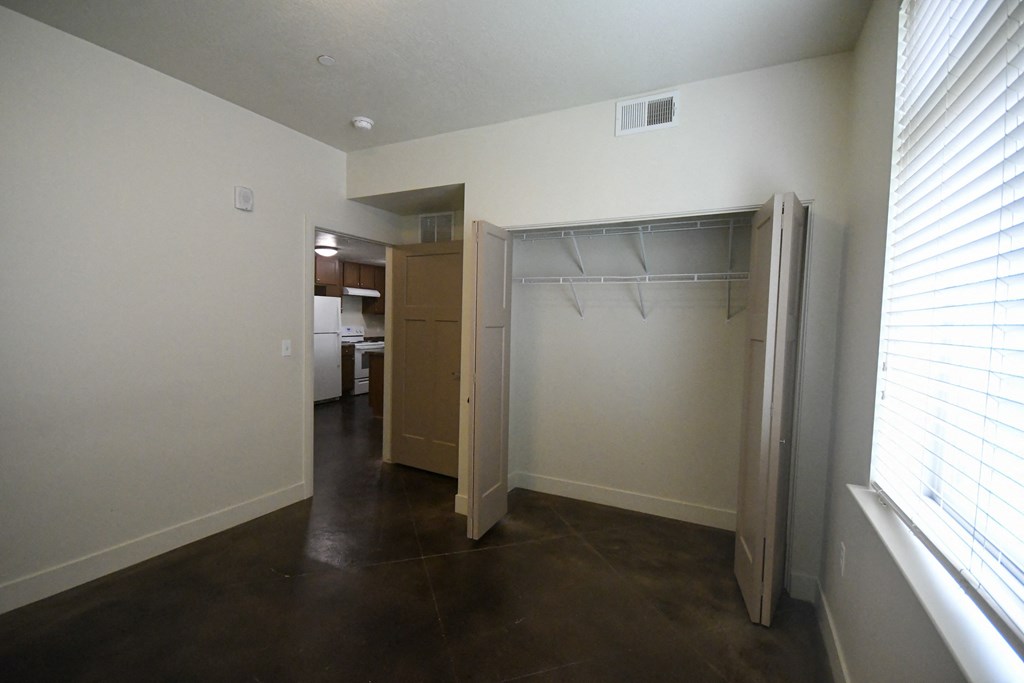 an empty room with a closet and a window