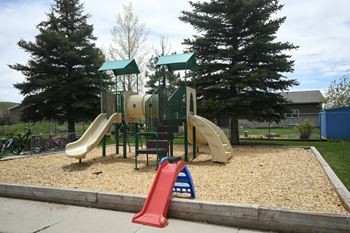 a playground with a mix of slides and climbing equipment in a park