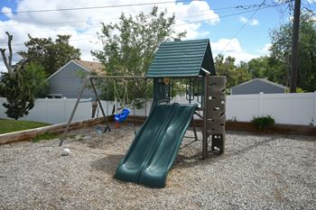 a playground with a swing set and a slide