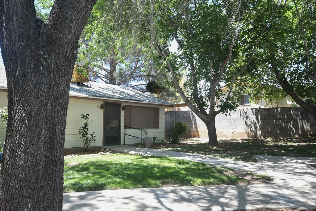 a house with a yard and trees in front of it