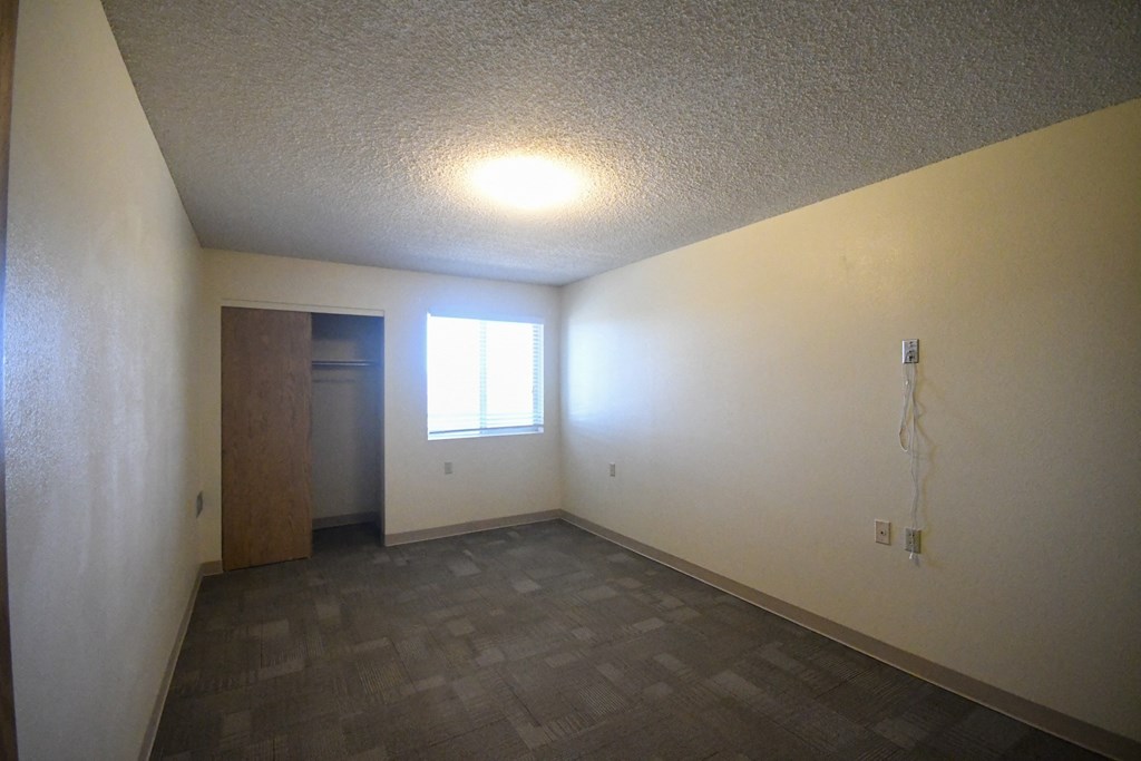 an empty living room with a window and a door