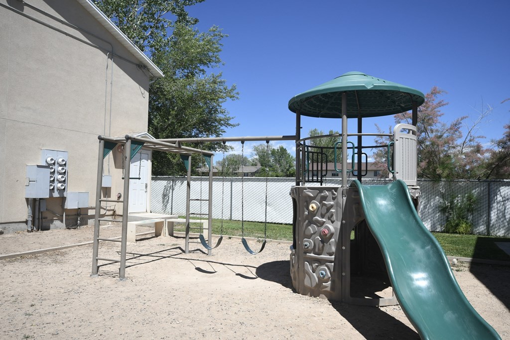 a playground with a play structure and a slide