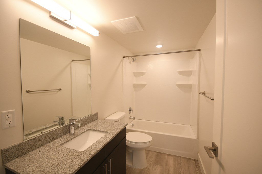 a bathroom with a shower sink and toilet and a mirror