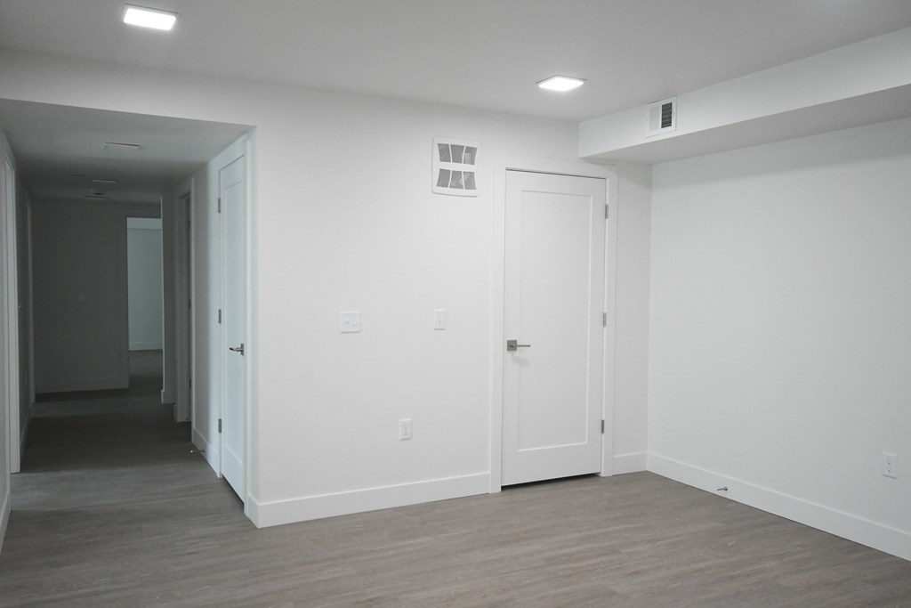an empty living room with white walls and a wood floor