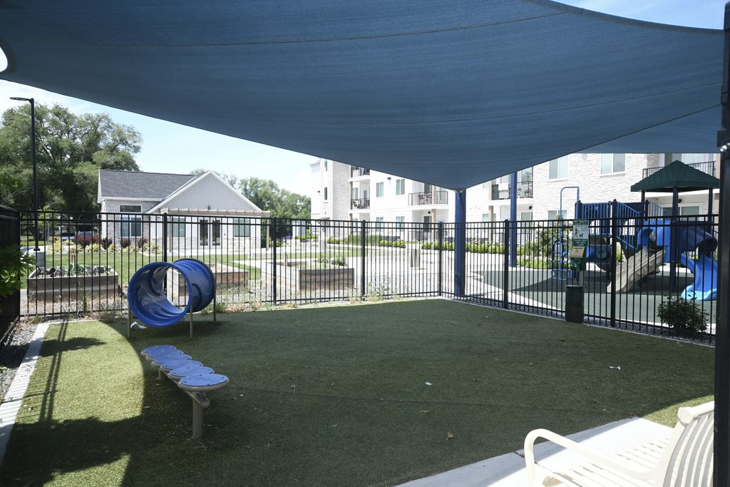 a backyard with a pool and a fence and a blue canopy