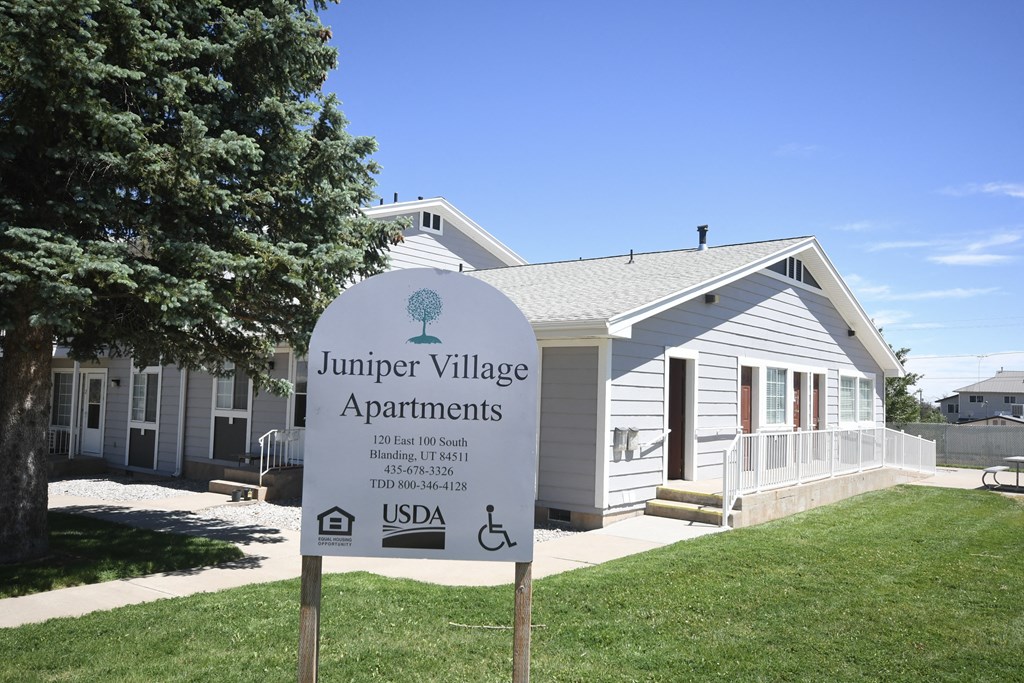 a white sign in front of a white house