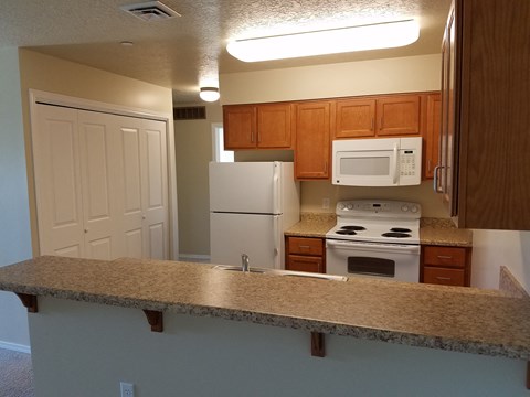 a kitchen with a granite counter top and white appliances