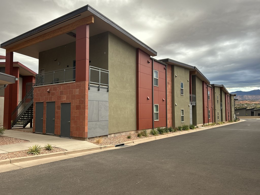 A series of small buildings with red and green exteriors are lined up in a row.