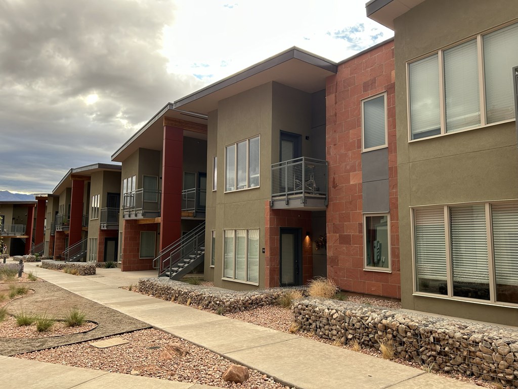 A row of modern houses with red brick and beige walls.