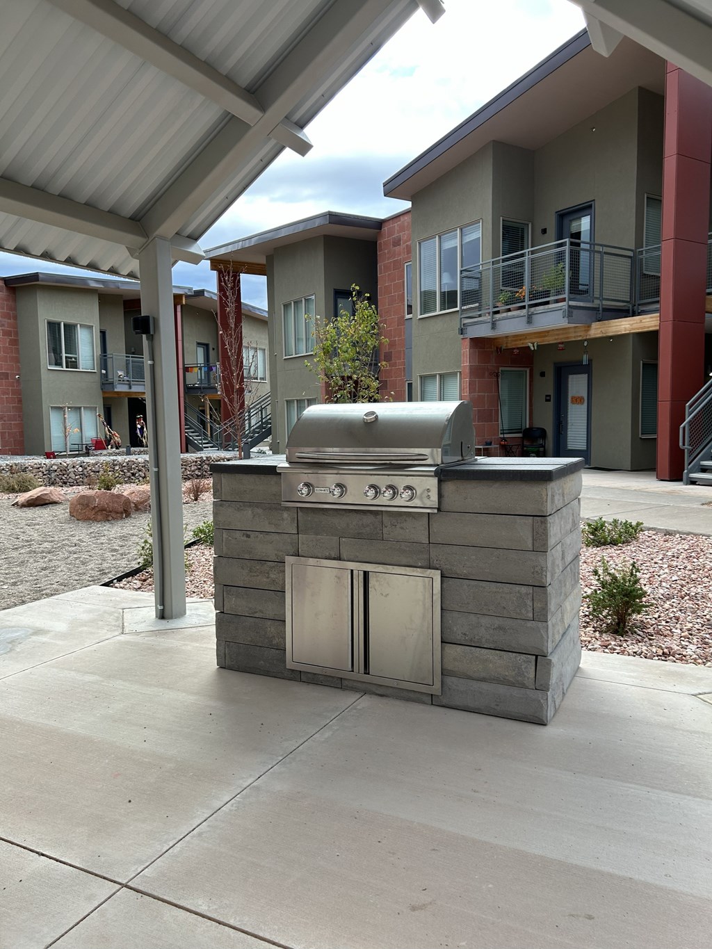 A small outdoor kitchen with a grill and sink.