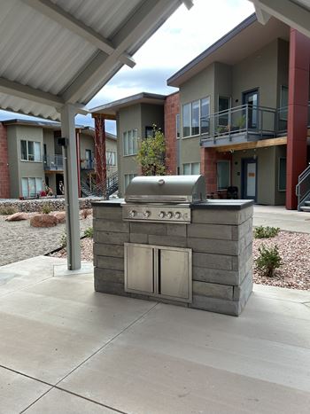 A small outdoor kitchen with a grill and sink.