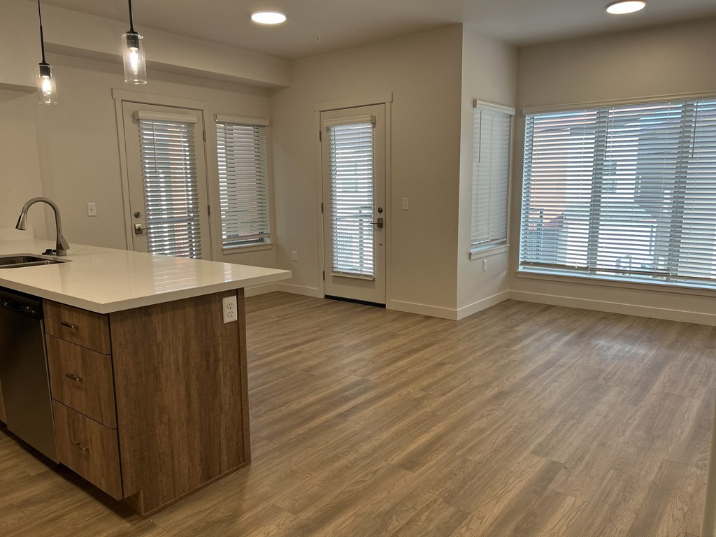 A kitchen with wooden floors and a white countertop.
