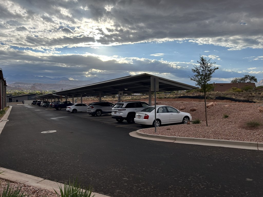 A parking lot with cars and a building in the background.
