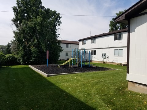 a backyard with a playground and a house