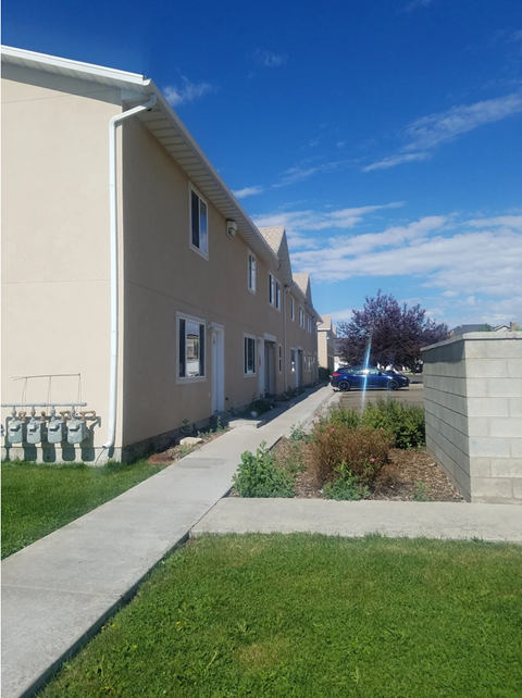 a row of houses with a sidewalk and grass
