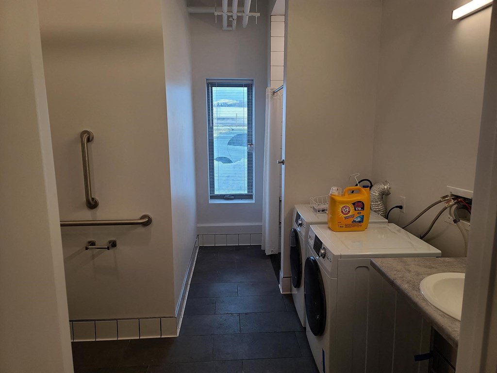 a laundry room with a washing machine and a window