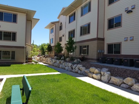 a green bench sits in front of a row of buildings