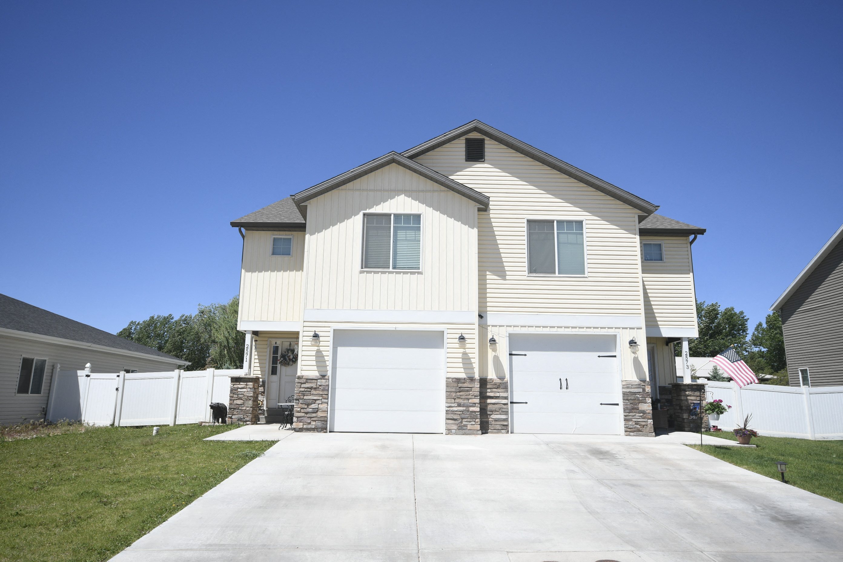 a white house with white doors and a driveway