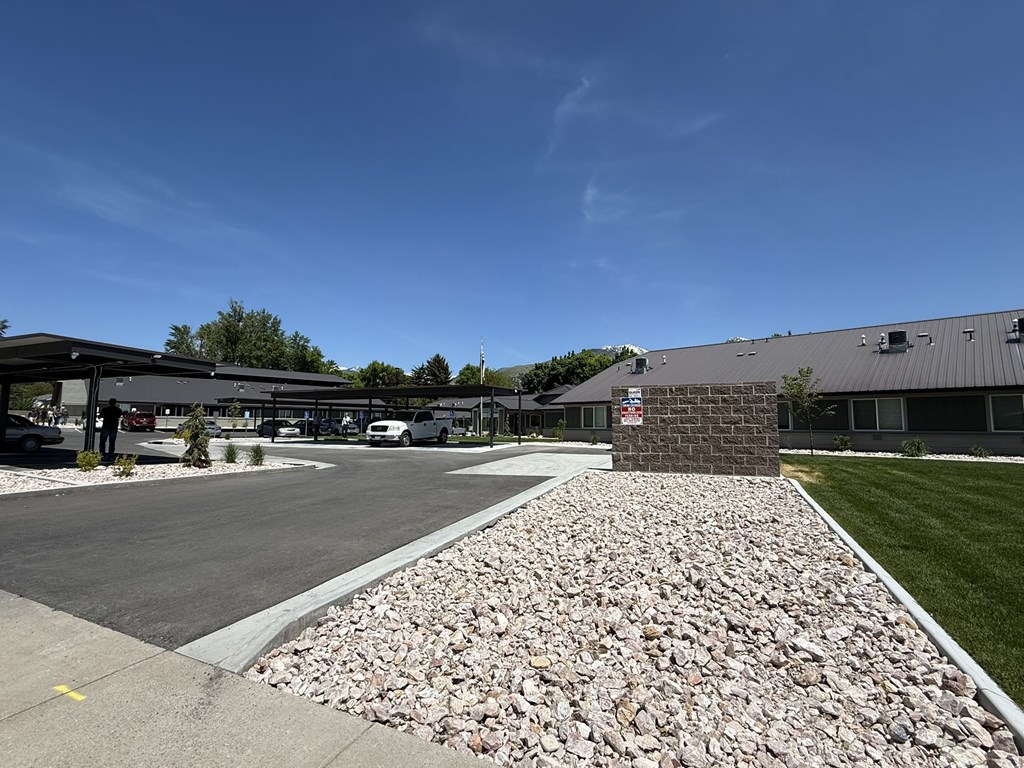 A parking lot with a gravel area in front of a building.