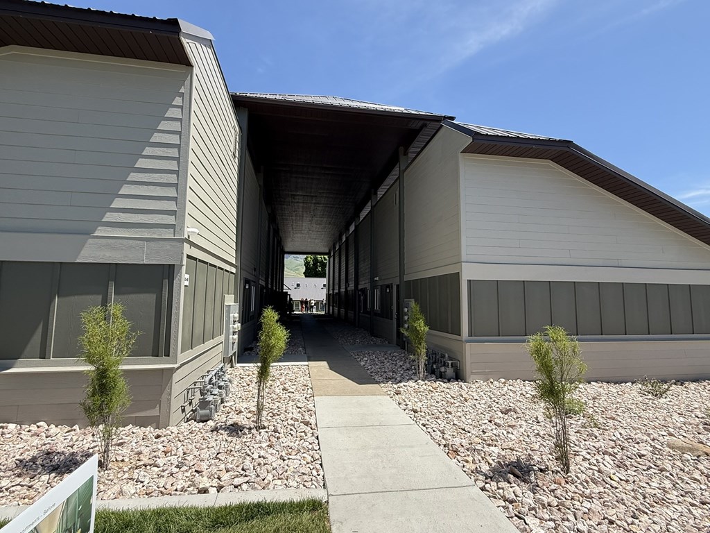 A modern building with a gravel pathway leading to the entrance.