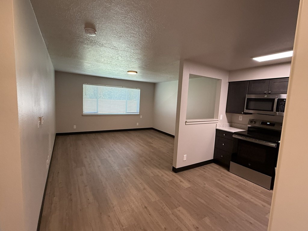 A kitchen area with a refrigerator, microwave, and oven.